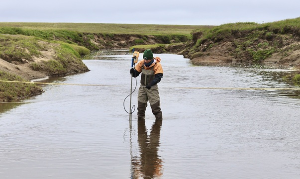 Hydrology & Surficial geologist collects streamflow measurements in the Kugrua River